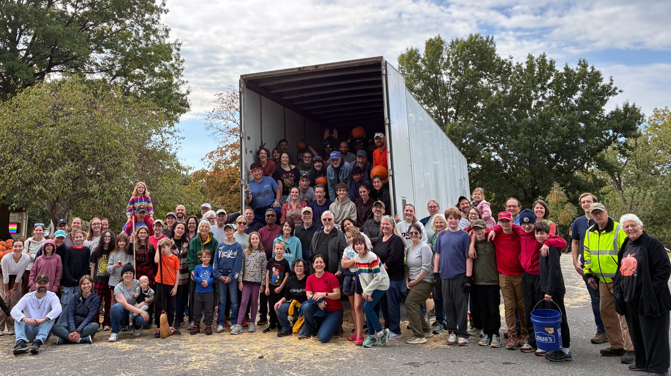 Group of Sunnyhillers smiling in front of a semi truck after unloading pumpkins
